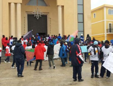 La protesta di un centinaio di eritrei davanti alla chiesa di Lampedusa. I migranti rifiutano di farsi prendere le impronte digitali, come impongono le norme comunitarie, Lampedusa, 6 gennaio 2015. ANSA/ FRANCESCO TERRACINA