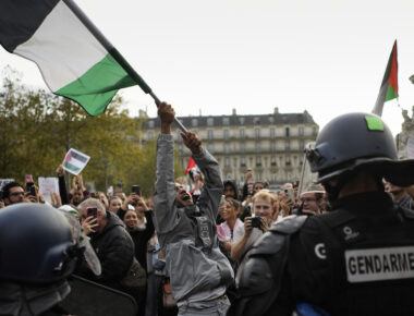 A protestor holds a Palestinian flag during a rally in solidarity with the Palestinian people in Gaza, in Paris, Thursday, Oct.12, 2023. (AP Photo/Thibault Camus)