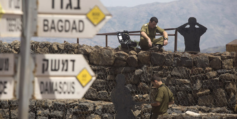 GOLAN HEIGHTS - MAY 10:  (ISRAEL OUT)  Israeli soldier is seen next to a signs pointing out distance to different cities on Mount Bental next to the Syrian border on May 10, 2018 in the Israeli-annexed Golan Heights. Some 20 rockets were fired at Israeli military bases by Iranian forces from southern Syria just after midnight on Thursday, sparking the largest ever direct clash between Jerusalem and Tehran, with Israeli jets targeting numerous Iranian-controlled sites across Syria. On Monday  U.S. President Donald Trump pulls out of the Iran deal.  (Photo by Lior Mizrahi/Getty Images)