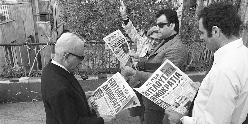 Athenians reading newspaper banner on the landslide defeat of the monarchy in Sunday's Plebiscite, December 9, 1974. Foreground headlines read. "Democracy at Last." (AP Photo)