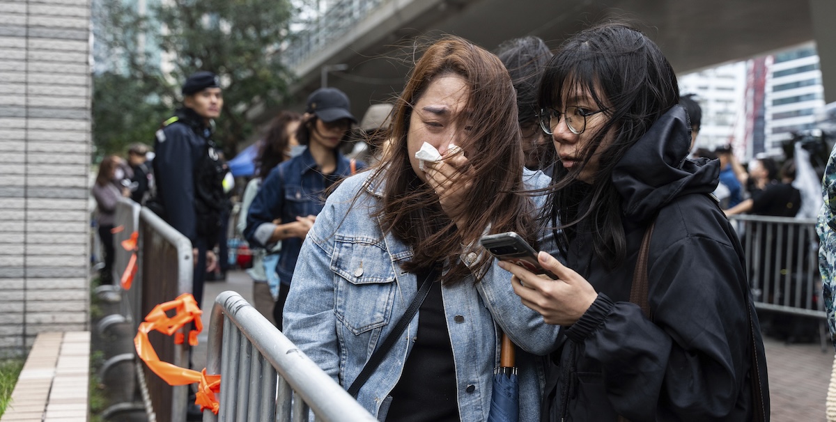 People leave the West Kowloon Magistrates' Courts in Hong Kong Tuesday, Nov. 19, 2024, following the sentencing in national security case. (AP Photo/Chan Long Hei)