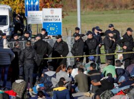 Bosnian and Croatian border police stand guard in front of migrants at Maljevac border crossing between Bosnia and Croatia near Velika Kladusa, Bosnia, October 24, 2018. REUTERS/Marko Djurica